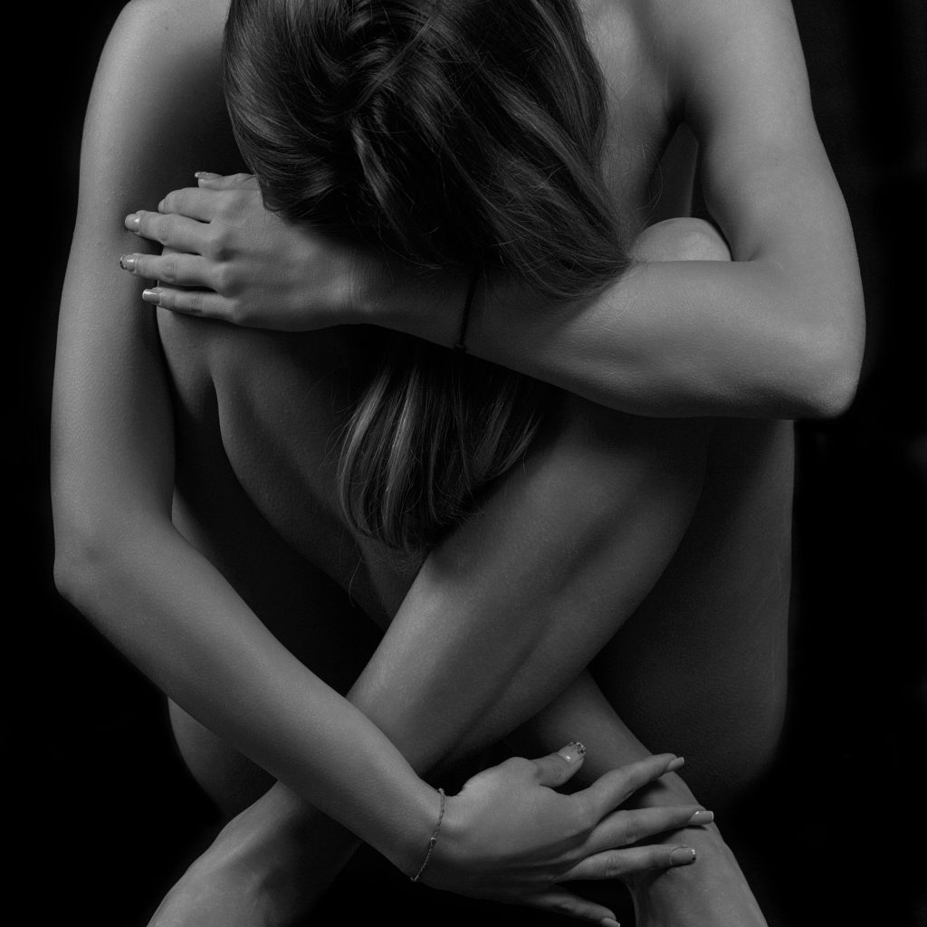 Sedinta foto de studio cu o femeie asezata cu bratele cuprinzand intregul corp