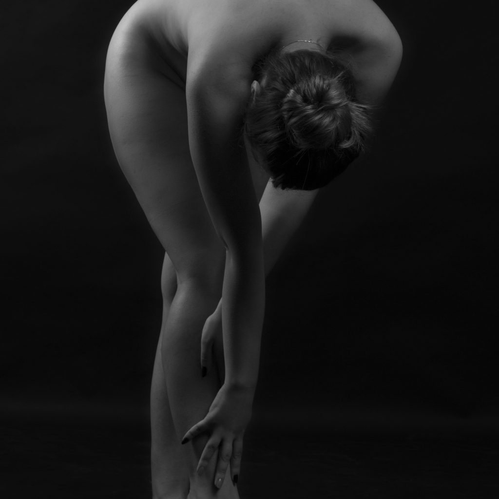 Femeie in postura feminina atingand picioarele sedinta foto studio