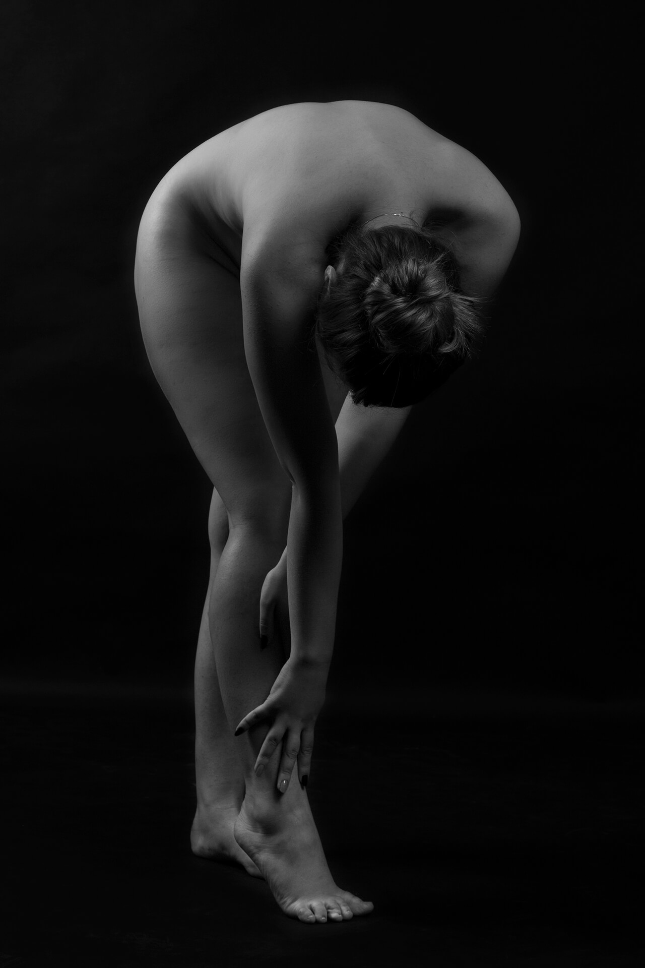 Fotografie artistică alb-negru, studiu al formei umane și flexibilității, portret fine art nude în studio cu iluminare dramatică
